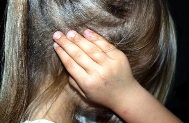 bambina mano orecchio