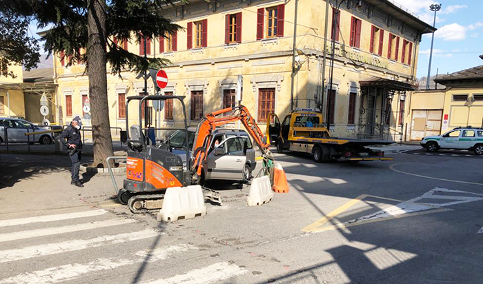 Incidente in centro città, auto centra un piccolo escavatore