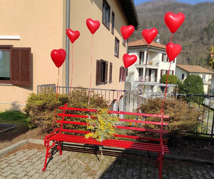 L'omaggio alle donne: palloncini e una mimosa sulla panchina rossa