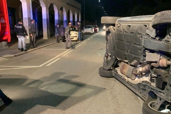 Urta un'auto in sosta e si cappotta in mezzo alla strada