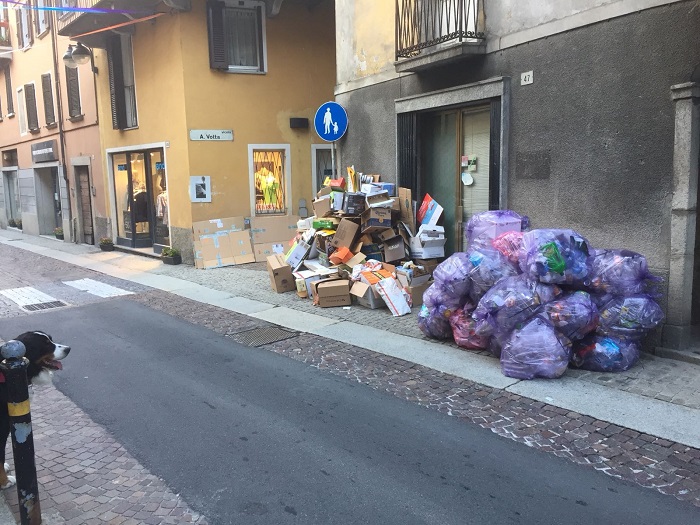 Via Mazzini ad Omegna invasa dai rifiuti in attesa che vengano portati via. Foto